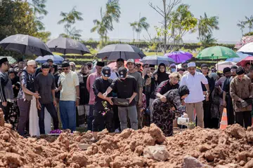 Ahli keluarga terdekat menaburkan bunga secara serentak di kubur (kiri) Allahyarham Mohammad Shahfiq Irman dan Allahyarham Mohamad Firman Nordin yang meninggal dunia dek satu nahas jalan raya di Johor. Pengebumian mereka telah dihadiri ratusan sanak saudara dan teman.