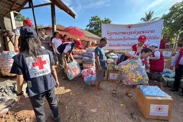 Sukarelawan daripada Palang Merah Singapura (SRC) dan Palang Merah Lao mengedarkan kit keperluan rumah kepada masyarakat yang terjejas oleh taufan Yagi di Myanmar.