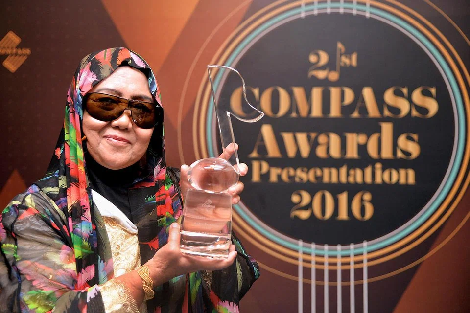 TURUT BANGGA DENGAN PENCAPAIAN ALLAHYARHAM SUAMI: Afida Es, isteri penyanyi 1960-an Allahyarham M. Osman, mempamerkan Anugerah Artistik Cemerlang yang diberikan sebagai menghargai pencapaian arwah suaminya dalam bidang muzik di acara Anugerah Compass ke-21 kelmarin. - Foto M.O. SALLEH