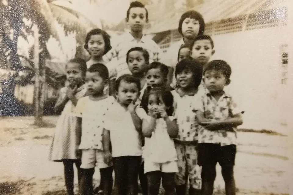 KENANGAN DI KAMPUNG: Encik Rahmat (baris depan, dua dari kiri) bersama adik-beradik dan saudara-maranya semasa berkumpul di rumah nenek mereka di Geylang. - Foto ihsan RAHMAT ABDUL KADIR