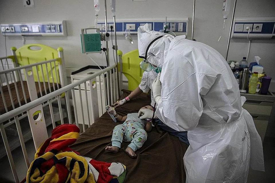 SI CILIK DIJANGKITI: Seorang doktor memeriksa seorang bayi yang diuji positif Covid-19 di sebuah hospital di Bogor pada 23 Jun lalu, sedang kadar jangkitan di Indonesia terus melonjak dan rumah sakit umum dibanjiri pesakit baharu, sekaligus memberi amaran akan krisis kesihatan yang mungkin berlaku hingga di luar kawalan di Indonesia. - Foto AFP