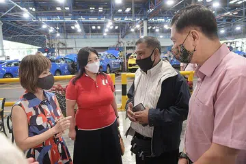 LANJUTKAN BANTUAN: (Dari kiri) Menteri Negara Kanan (Pengangkutan merangkap Kemampanan dan Sekitaran), Dr Amy Khor, bersama Pengarah NTUC, Cik Yeo Wan Ling dan Ketua eksekutif ComfortDelGro Taxi, Encik Ang Wei Neng (paling kanan) , berinteraksi dengan pemandu teksi Encik Ismail Maideen (tiga dari kiri) di Pusat ComfortDelGro di Braddell semalam. - Foto BH oleh ALPHONSUS CHERN