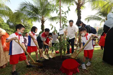 TANAM POKOK: Encik Lawrence Wong (tiga dari kanan) dan anggota Parlimen GRC Marsiling-Yew Tee turut serta di acara menanam pokok berhampiran Blok 402 Woodlands Street 41, disertai penduduk serta kanak-kanak dari pusat Prasekolah Yayasan Masyarakat PAP di kawasan itu.