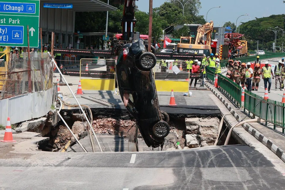 DISELAMATKAN: Pemandu wanita itu berada dalam keadaan sedar ketika dibawa ke Hospital Raffles dan kereta yang dipandunya dikeluarkan daripada lubang benam yang terbentuk di Tanjong Katong Road pada 26 Julai.