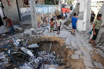 Kanak-kanak Palestin melihat kerosakan yang berlaku di sekolah kelolaan agensi Pertubuhan Bangsa-Bangsa Bersatu (PBB) ekoran pengeboman tentera Israel di kawasan Nuseirat, tengah Gaza, pada 9 Julai.