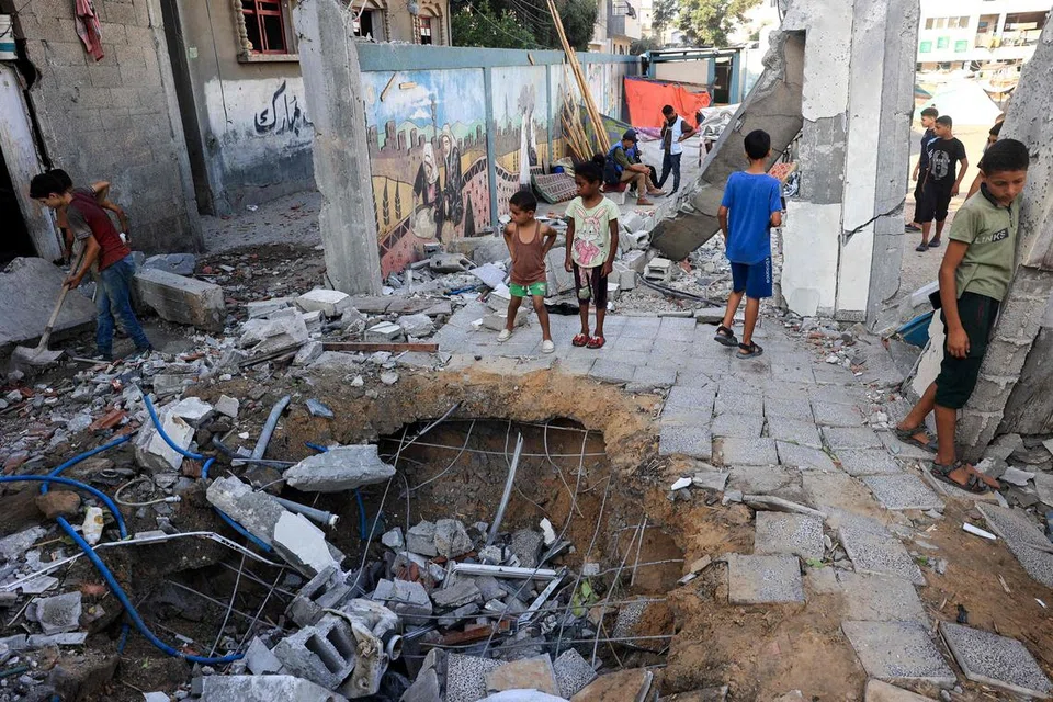 Kanak-kanak Palestin melihat kerosakan yang berlaku di sekolah kelolaan agensi Pertubuhan Bangsa-Bangsa Bersatu (PBB) ekoran pengeboman tentera Israel di kawasan Nuseirat, tengah Gaza, pada 9 Julai.