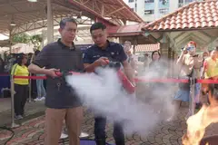 Profesor Madya Dr Muhammad Faishal Ibrahim (kiri) di acara Akar Umbi Masyarakat di Nee Soon Central di mana penduduk diajar cara menggunakan alat pemadam api. 