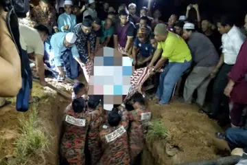 Seramai 20 anggota Jabatan Bomba dan Penyelamat Malaysia (JBPM) Kelantan bersama penduduk kampung membantu mengangkat jenazah Allahyarham Sheikh Mohd Ali Omar, 44 tahun, lelaki obesiti, untuk di kebumikan di Tanah Perkuburan Islam Kampung Jaya, Pasir Hor, Kota Bharu, Kelantan, pada 15 Disember malam.