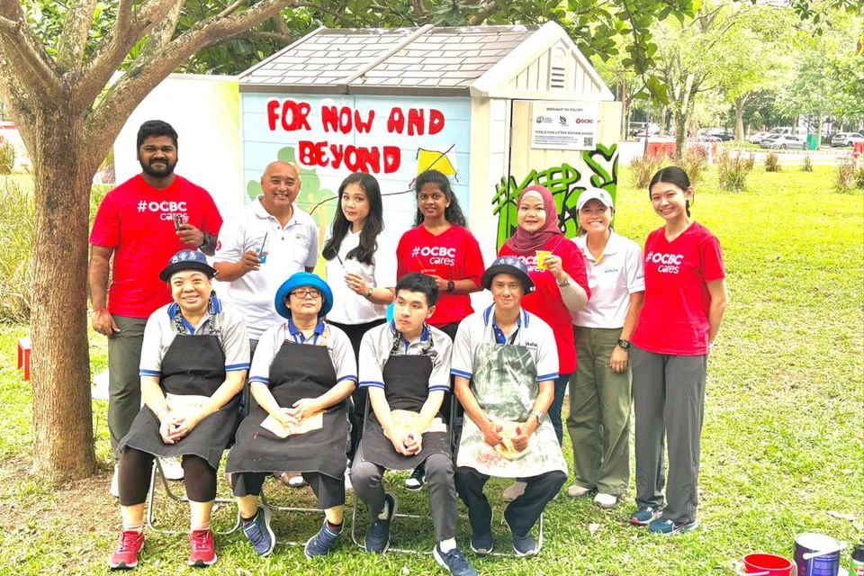 Pengerusi, Majlis Kebersihan Awam (PHC), Encik Andrew Khng (belakang dua dari kiri); Pengarah Eksekutif, PHC, Dr Christina Liew (belakang tiga dari kiri); bersama kakitangan OCBC, wakil Persatuan Golongan Kurang Daya Intelek Singapura (Minds) dan pelatih semasa pelancaran CleanPod yang diperbaharui.