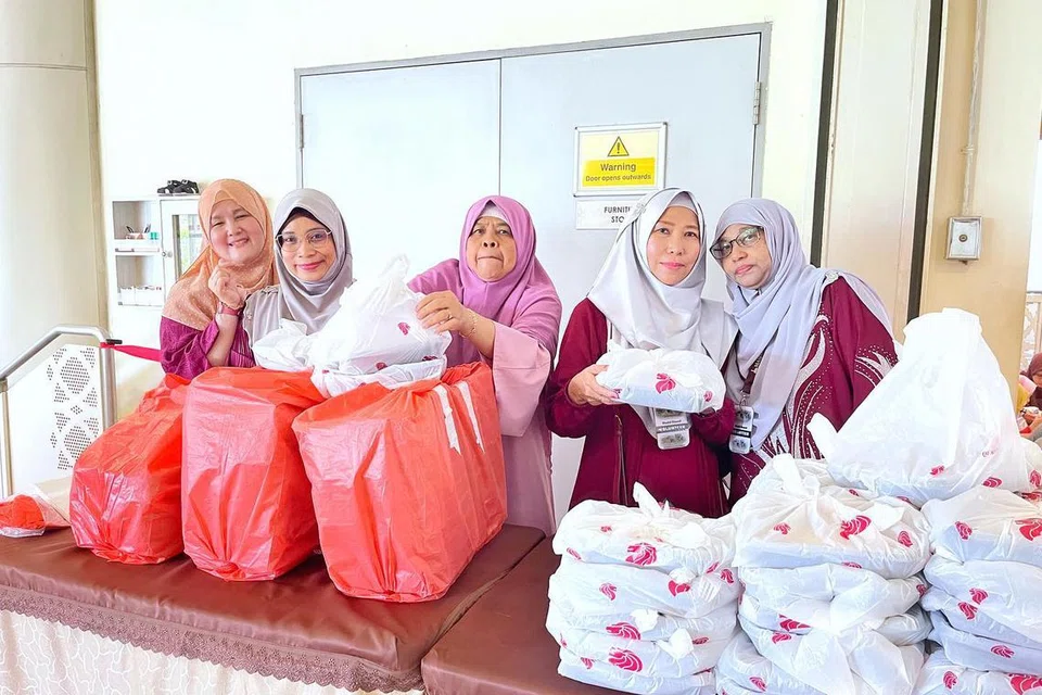 Kakitangan dan relawan masjid mengagihkan makanan di Masjid Maarof.
