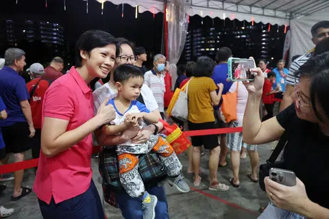 Anggota Parti Tindakan Rakyat (PAP), Cik Deryne Sim (kiri) bersama penduduk pada acara pelancaran sambutan Tahun Baru Cina ‘Springtime Splendour@Nee Soon’ anjuran Persatuan Rakyat (PA) bagi menandakan permulaan Tahun Baru Cina di padang terbuka bersebelahan Kolam Yishun.