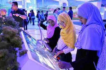TIMBA ILMU DI PAMERAN: Aneesah Eiliyah Chan (dua dari kanan) seronok mempelajari tentang masa depan Singapura dan warga serta langkah yang boleh diambil hari ini bagi memastikan generasi akan datang dapat menjalani kehidupan yang selesa. - Foto KHALID BABA