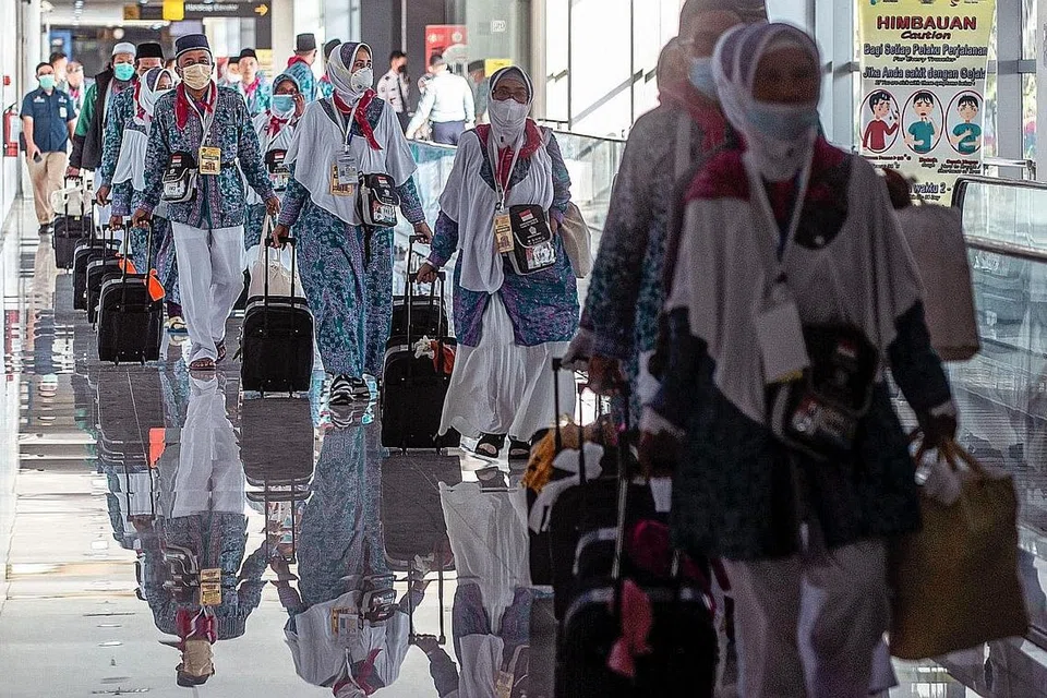 BERANGKAT: Sebahagian daripada kumpulan pertama jemaah haji Indonesia yang berlepas dari Lapangan Terbang Antarabangsa Juanda di Surabaya pada 4 Jun. Semua jemaah akan diberi beg berisi peralatan kesihatan seperti pelitup dan sanitasi tangan. - Foto AFP