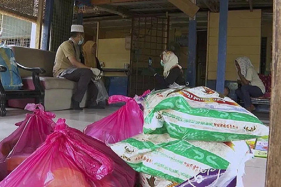 SEDEKAH MERENTASI SEMPADAN: Pemberian barangan makanan dilaksanakan pada awal Ogos lalu di Plentong, Johor Bahru. Sebanyak 100 pek makanan telah diagihkan kepada fakir miskin dan setiap pek bernilai $35 dolar, hasil sumbangan warga Singapura. - Foto ihsan USTAZ MAHFUZ AL-HAFIZ ABDUL RAHMAN