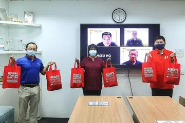 TUNJUKKAN KEPEDULIAN: Encik Chee Hong Tat (paling kanan) dan Encik Seah Kian Peng (paling kiri) menyampaikan pek peduli kepada Cik K. Thanaletchimi di ibu pejabat kesatuan itu di Jalan Bukit Pasoh kelmarin. - Foto NTUC