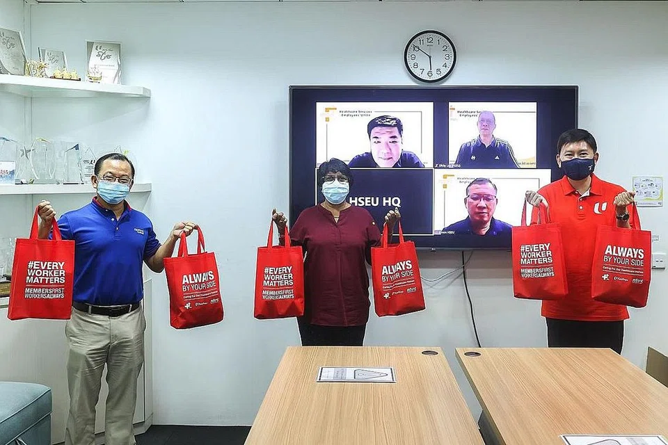 TUNJUKKAN KEPEDULIAN: Encik Chee Hong Tat (paling kanan) dan Encik Seah Kian Peng (paling kiri) menyampaikan pek peduli kepada Cik K. Thanaletchimi di ibu pejabat kesatuan itu di Jalan Bukit Pasoh kelmarin. - Foto NTUC