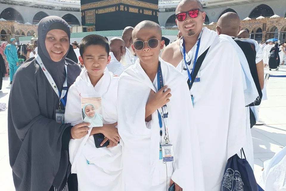 Encik Mohammed Ashraff Hussin bergambar bersama isteri, Cik Mardalina Mohamed Nossi, dan anak kembarnya Qayyim Fazhan Mohammed Ashraff (dua dari kiri) dan Qayyim Iylhan Mohammed Ashraff semasa menunaikan umrah pada Disember 2023. Cik Mardalina kelihatan memegang gambar Allahyarhamha Raisya Ufairah yang meninggal dunia pada 2022 akibat Covid-19.