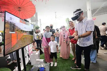 PEMBELAJARAN SEPANJANG HAYAT: Merasmikan pesta itu, Encik Zaqy (kanan) telah mengadakan lawatan ke Pesta Pembelajaran 2022, anjuran Mendaki di Kampung Admiralty semalam. Beliau dilihat mencuba stesen permainan VR. - Foto MENDAKI
