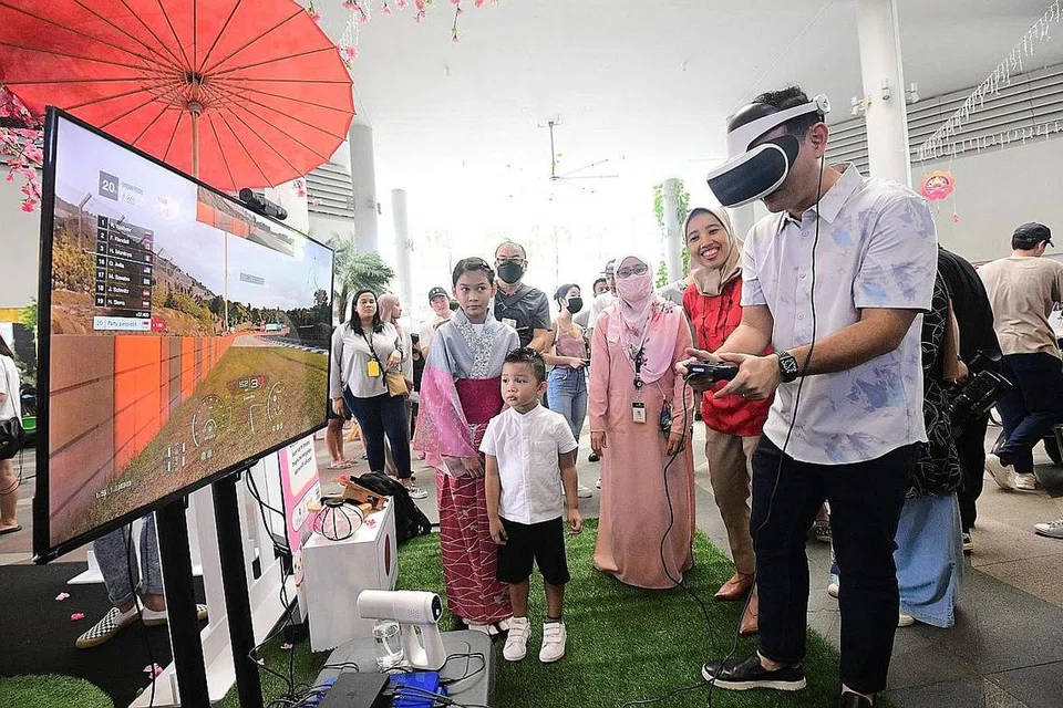 PEMBELAJARAN SEPANJANG HAYAT: Merasmikan pesta itu, Encik Zaqy (kanan) telah mengadakan lawatan ke Pesta Pembelajaran 2022, anjuran Mendaki di Kampung Admiralty semalam. Beliau dilihat mencuba stesen permainan VR. - Foto MENDAKI