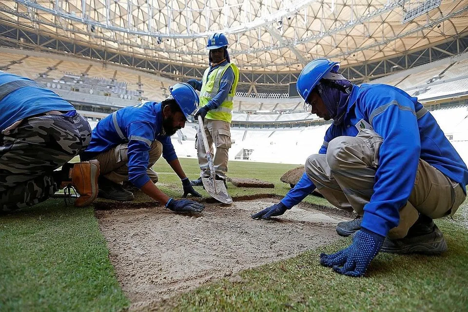 HAK DIJAGA: Dalam laporan sebelum pertandingan bermula, Amnesty menekankan kepada Fifa, agar menubuhkan dana pampasan bagi buruh migran yang didera. Dalam foto ini pekerja migran sedang menampal rumput dalam Stadium Lusail Stadium, stadium bagi Final Piala Dunia Qatar. - REUTERS