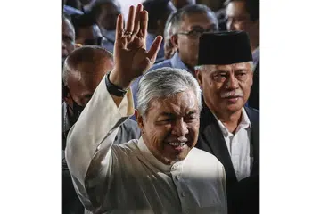 LAMBAIAN GEMBIRA: Datuk Ahmad Zahid melambai kepada penyokongnya yang telah berkumpul di luar mahkamah sejak pagi semalam. - Foto EFA-EFE