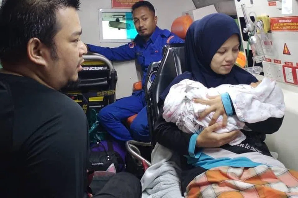 BANTUAN SEGERA: Anggota Angkatan Pertahanan Awam Malaysia (APM) membantu pasangan membawa bayi mereka yang baru lahir untuk ke Klinik Kesihatan Seri Langkap, Setiu, Terengganu, selepas jalan raya di kawasan penempatan mereka di Kampung Kasar dinaiki air akibat banjir.