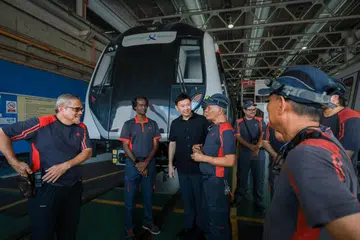 BERI PENGHARGAAN: Pemangku Menteri Pengangkutan, Encik Chee Hong Tat (tiga dari kiri), beramah mesra dengan kakitangan SMRT yang telah menjayakan program pembaharuan itu pada Rabu di Depoh Bishan.