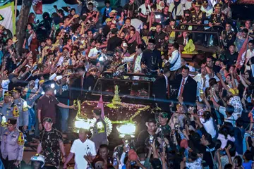 
Mantan presiden Indonesia, Encik Joko  Widodo (tengah, berbaju hitam), bersama isterinya, Cik Iriana (kanan Encik Widodo), disambut ribuan penduduk di kampung halamannya, Solo, Jawa Tengah, pada 20 Oktober.  