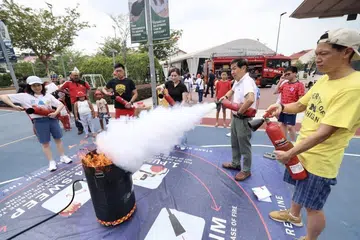 BELAJAR PADAM API: Pada Hari Kesediaan Menghadapi Kecemasan di Joo Chiat, kira-kira 300 orang penduduk diajar cara menggunakan alat pemadam api melalui sesi tunjuk ajar pemadaman kebakaran secara langsung oleh pegawai Pasukan Pertahanan Awam Singapura (SCDF).