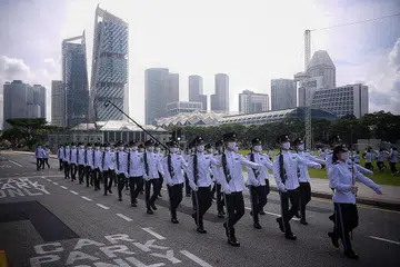 BERSKALA KECIL: Perbarisan berskala kecil dengan setiap kontinjen mempunyai 36 peserta iaitu separuh berbanding tahun-tahun lalu dek langkah jarak selamat yang diadakan bersama dengan Tembak Hormat Presiden di Padang pada segmen pagi sambutan Hari Kebangsaan. - Foto-foto BH oleh MARK CHEONG 