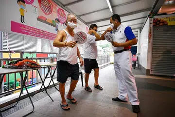 BERAMAH-TAMAH: Calon PAP Shamsul Kamar beramah-tamah semasa jejak kempen terakhir beliau di pasar dan pusat makanan di Bedok North Street 3. - Foto BH oleh LIM YAOHUI