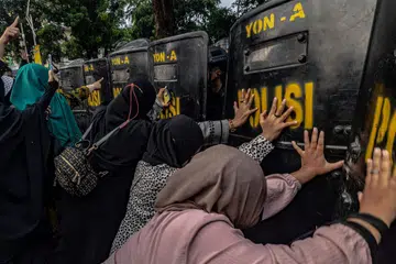 BANTAH KONSERT: Penunjuk perasaan menolak perisai pegawai polis antirusuhan ketika mereka menuntut pembatalan konsert oleh kumpulan rok Britain, Coldplay, berhampiran stadium Gelora Bung Karno, pada Rabu, di mana kumpulan itu mengadakan persembahan pada hari yang sama di Jakarta.