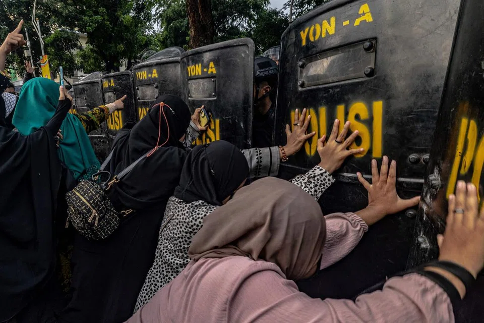 BANTAH KONSERT: Penunjuk perasaan menolak perisai pegawai polis antirusuhan ketika mereka menuntut pembatalan konsert oleh kumpulan rok Britain, Coldplay, berhampiran stadium Gelora Bung Karno, pada Rabu, di mana kumpulan itu mengadakan persembahan pada hari yang sama di Jakarta.
