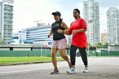 Cik Siti Fairus Rahmad (kanan) dan pemandu arah yang juga sukarelawan, Cik Sunita Riar, berlari-lari anak sebagai sebahagian daripada sesi latihan.