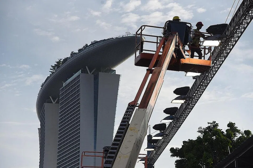 KE ARAH MAMPAN: Pekerja melaras lampu berhampiran Orange@Pit Grandstand bagi Grand Prix Singapura Jumaat lalu. Semua lampu di trek dalam perlumbaan tahun depan akan digantikan dengan lampu LED lebih cekap tenaga. - Foto BH oleh DESMOND WEE