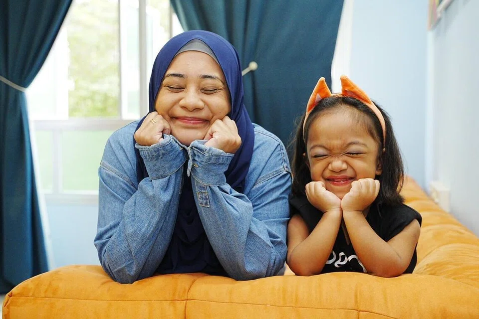 Sebagai seorang pendidik awal kanak-kanak, Cik Nurul Sharbana Rennie (kiri), menggunakan pengetahuan perkembangan kanak-kanak untuk memastikan Nuha mencapai tahap perkembangan mengikut kemampuannya sendiri. 