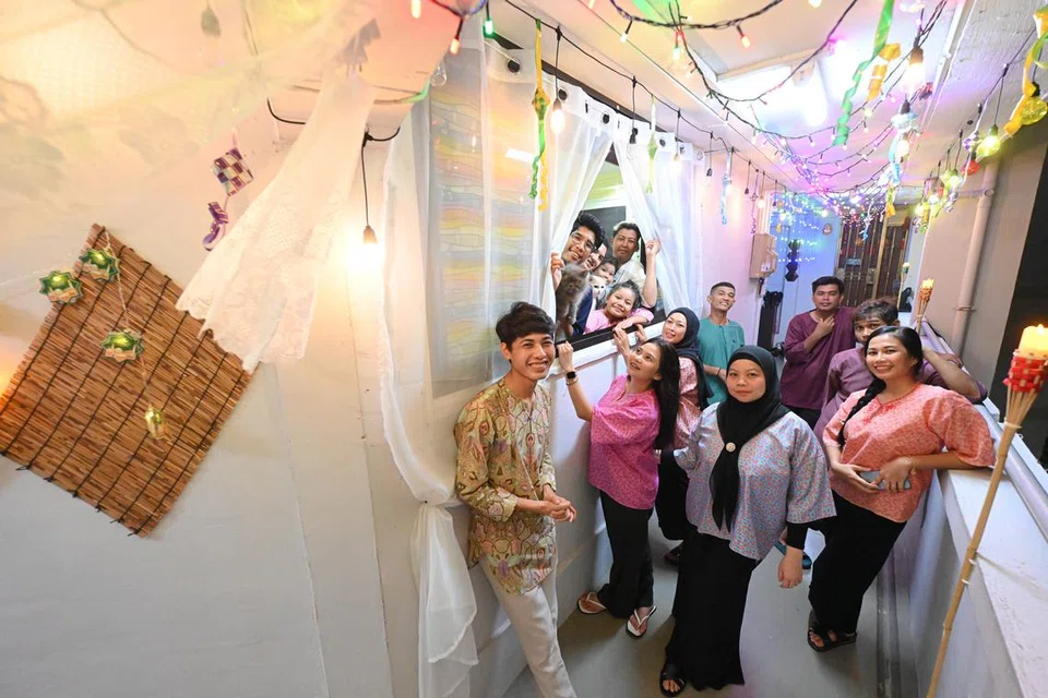 Keluarga Encik Farid Difari (baju biru) bergambar dengan hiasan lampu lap-lip mereka bertemakan ala kampung bagi tahun 2024.