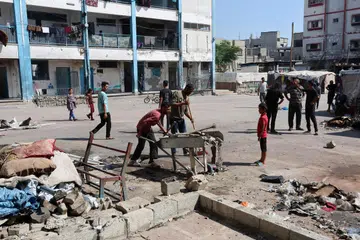 Penduduk Palestin memeriksa lokasi serangan udara Israel yang berlaku pada waktu malam ke atas sebuah sekolah yang menempatkan pelarian, di kem pelarian Bureij, tengah Jaluran Gaza, 17 Julai 2025.
