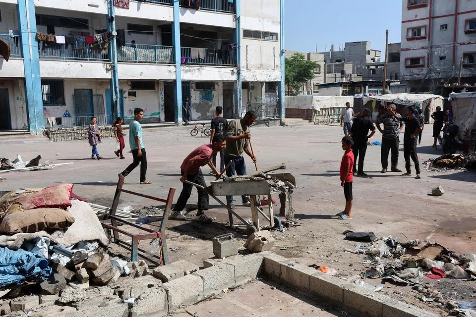 Penduduk Palestin memeriksa lokasi serangan udara Israel yang berlaku pada waktu malam ke atas sebuah sekolah yang menempatkan pelarian, di kem pelarian Bureij, tengah Jaluran Gaza, 17 Julai 2025.