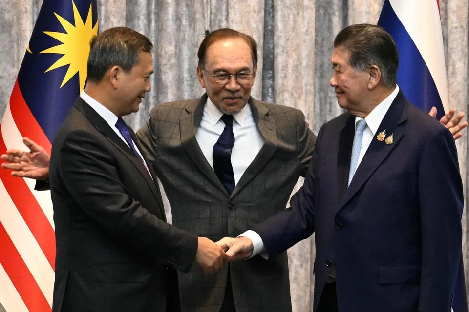 Perdana Menteri Kemboja, Hun Manet (kiri) dan Pemangku Perdana Menteri Thailand, Phumtham Wechayachai (kanan) berjabat tangan sambil Perdana Menteri Malaysia, Datuk Seri Anwar Ibrahim (tengah) merangkul bahu mereka selepas sidang media berikutan rundingan gencatan senjata antara Thailand dan Kemboja di Putrajaya, Malaysia, 28 Julai 2025. Para pemimpin Thailand dan Kemboja bertemu bagi rundingan damai ketika pertikaian wilayah di sempadan mereka berlarutan ke hari kelima pertempuran terbuka. 