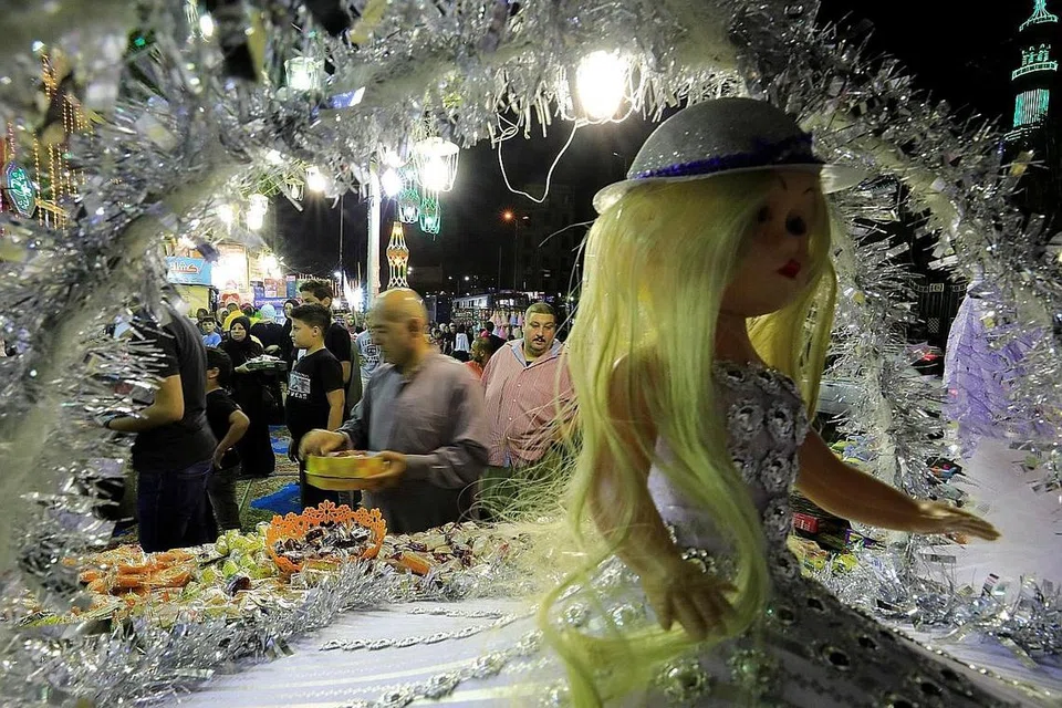 SAMBUT MAULIDUR RASUL DALAM SUASANA MERIAH: Sebahagian rakyat Syria menyambut maulid dengan membaca kitab bagi memperingati kisah hidup dan perjuangan Rasulullah saw di Masjid Umayyad di bandar lama Damsyik pada malam Isnin lalu. Di Mesir pula, orang ramai mengadakan sambutan Maulidur Rasul secara besar-besaran dan amat meriah dengan keluar beramai-ramai membeli manis-manisan yang dijual di merata tempat. Kedai-kedai menjual manisan ini dihiasi dengan lampu berwarna-warni dan kelihatan terang-benderang, seperti yang kelihatan di kejiranan Sayeda Zainab, dekat Kahirah (gambar atas). - Foto-foto EPA-EFE, REUTERS