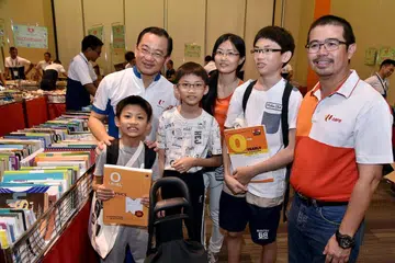 KEPERLUAN SEKOLAH: Encik Zainal Sapari (kanan) dan Ketua Pegawai Eksekutif NTUC FairPrice, Encik Seah Kian Peng (kiri), yang juga AP GRC Marine Parade, bergambar dengan benefisiari yang meraih manfaat daripada inisiatif FairPrice Share-A-Textbook dan NTUC Back to School, semalam. - Foto NTUC/NTUC FAIRPRICE.