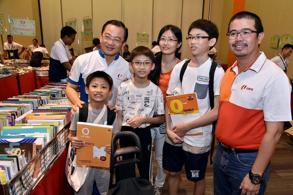 KEPERLUAN SEKOLAH: Encik Zainal Sapari (kanan) dan Ketua Pegawai Eksekutif NTUC FairPrice, Encik Seah Kian Peng (kiri), yang juga AP GRC Marine Parade, bergambar dengan benefisiari yang meraih manfaat daripada inisiatif FairPrice Share-A-Textbook dan NTUC Back to School, semalam. - Foto NTUC/NTUC FAIRPRICE.