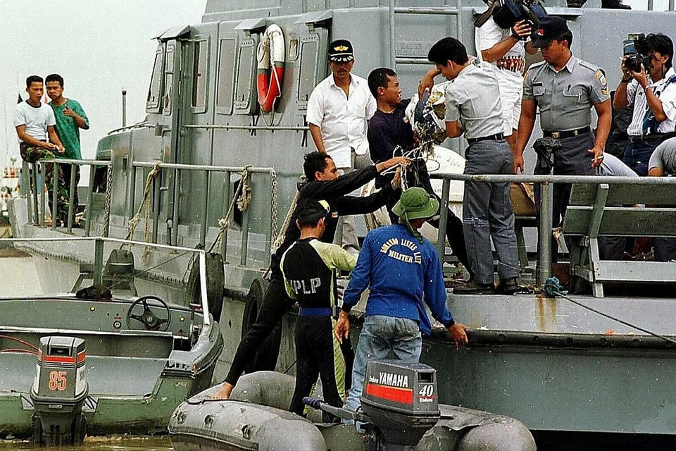 SALING MEMBANTU: Anggota penyelam TNI terlibat dalam operasi mencari menyusuli nahas udara pesawat Silkair MI 185 pada 1997. - Foto fail