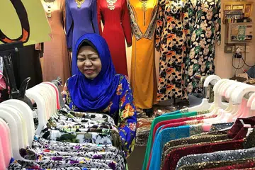 TAMBAH SELESA DAN BERSIH: Cik Sadiah Hamid, pengendali gerai menjual baju wanita Zshan, mengatakan bahawa ramai pelanggan gembira pengalihudaraan pasar Geylang Serai semakin baik. - Foto-foto SITI AISYAH NORDIN