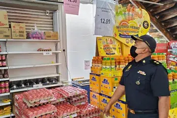 PANTAU BEKALAN: Seorang anggota penguat kuasa Kementerian Perdagangan Dalam Negeri dan Kos Sara Hidup Johor membuat pemeriksaan bekalan dan harga telur di sebuah pasar raya di Johor.