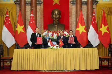 PERKUKUH KERJASAMA TENAGA: (Dari kiri) MOU kerjasama dalam bidang tenaga telah ditandatangani Dr Tan (kiri) dan Encik Dien (kanan) disaksikan Presiden Halimah (dua dari kiri) dan Presiden Phuc (dua dari kanan). - Foto MCI