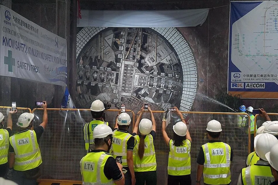 PENYAMPAIAN PENTING: Pekerja merakam pencapaian dalam menyelesai kerja penerowongan bagi peluasan MRT Laluan Circle di stesen Cantonment semalam. Ia bermakna 55 peratus kerja sivil projek yang bermula pada 2019 itu telah selesai. - Foto BH oleh Alphonsus Chern