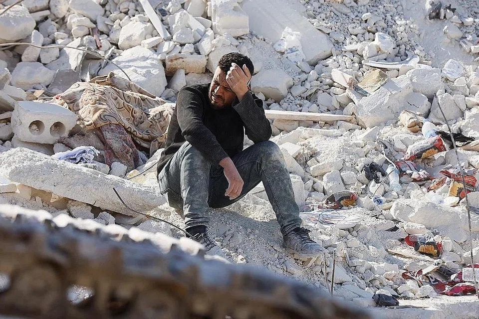 RATAPI KEHILANGAN: Seorang lelaki dilihat terduduk dan menangis di atas runtuhan sebuah rumah yang pernah didiami keluarganya dengan sebilangan mereka terkorban ekoran gempa bumi di bandar Harem, Idlib, Syria. - Foto REUTERS