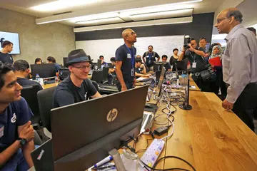 HIMPUNKAN BAKAT TEKNOLOGI: Encik Tharman (paling kanan) sedang bercakap dengan salah seorang bakat di Entrepreneur First yang beroperasi di SGInnovate. - Foto ZAOBAO